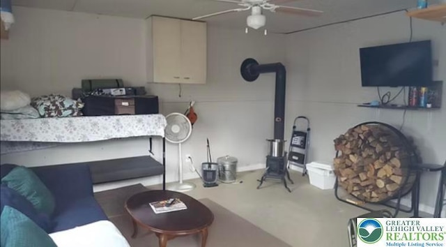 living area with a ceiling fan and concrete flooring