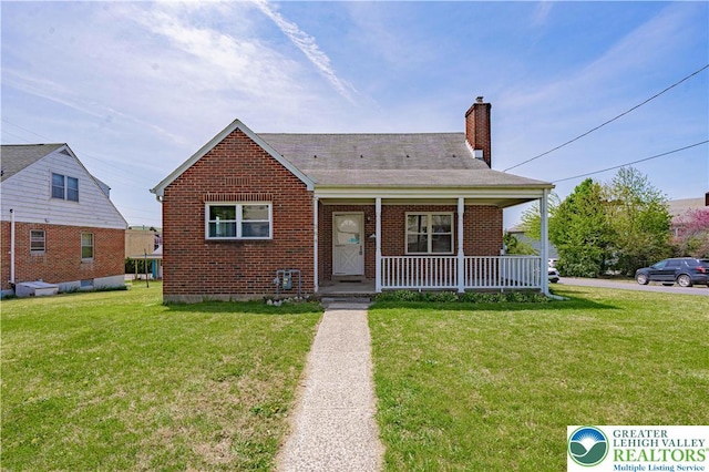 bungalow featuring covered porch, brick siding, a front lawn, and a chimney
