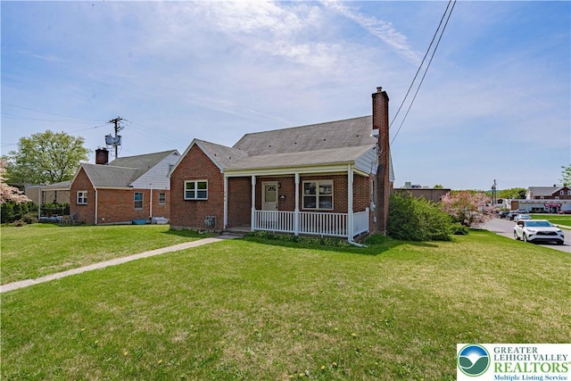 bungalow featuring a front lawn, a porch, a chimney, and brick siding