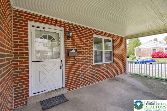 entrance to property featuring brick siding