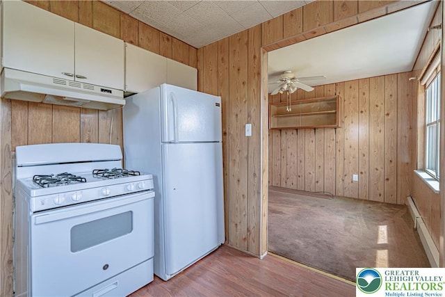 kitchen with a ceiling fan, light wood-style flooring, under cabinet range hood, white appliances, and wooden walls