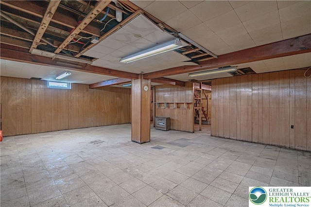 basement with wooden walls and tile patterned floors