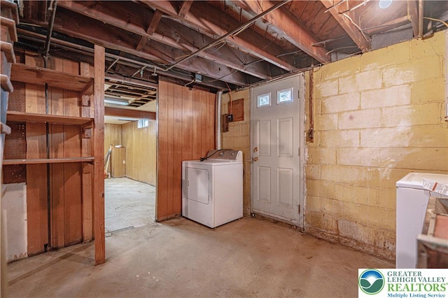 unfinished below grade area with washing machine and dryer and concrete block wall
