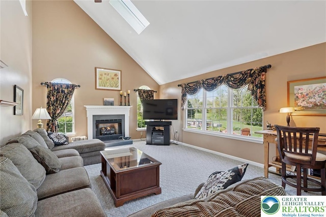 2735 Limeport Rd, Milford Twp, PA 18951 - carpeted living room featuring a warm lit fireplace, baseboards, a healthy amount of sunlight, high vaulted ceiling, and a skylight