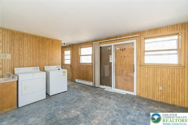laundry room featuring a sink, laundry area, baseboard heating, independent washer and dryer, and wooden walls