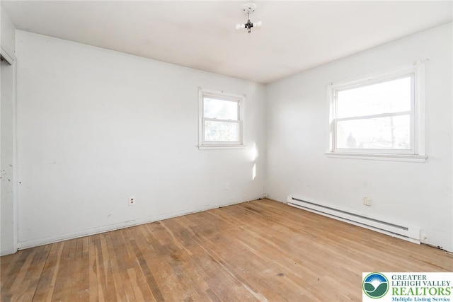 spare room with hardwood / wood-style floors and baseboard heating