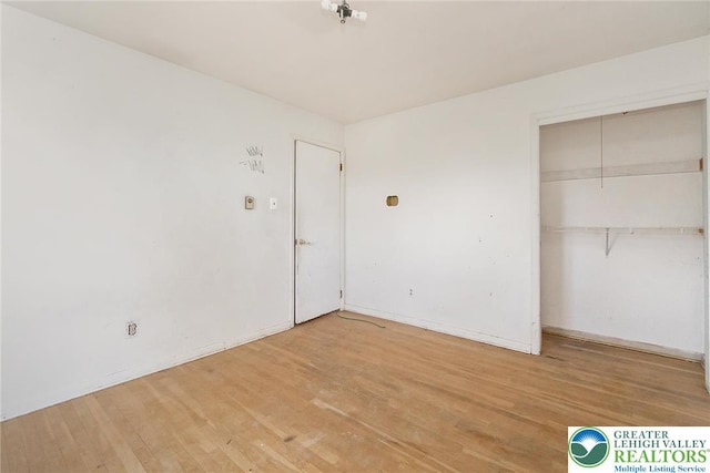 unfurnished bedroom featuring a closet and light wood-style flooring