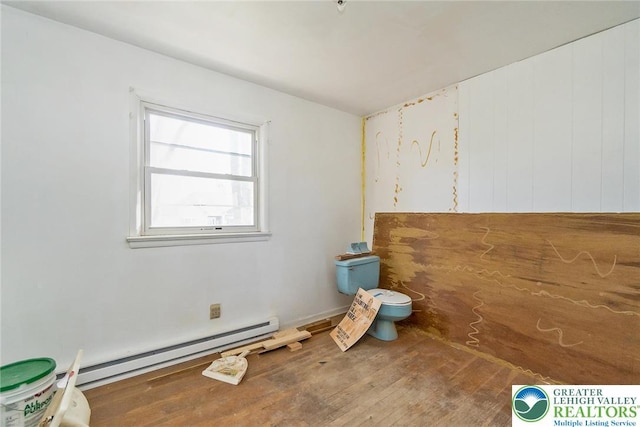 bathroom featuring toilet, wood finished floors, and a baseboard heating unit
