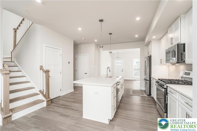 1022 Watson Ct, Upper Macungie Twp, PA 18051 - kitchen with stainless steel appliances, light wood-type flooring, a sink, an island with sink, and white cabinets