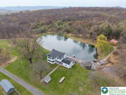 aerial view with a forest view and a water view