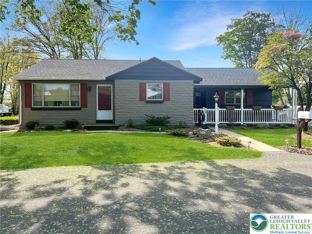 3426 Wilson Ave, South Whitehall Twp, PA 18069 - view of front of home featuring stone siding, a porch, roof with shingles, and a front yard