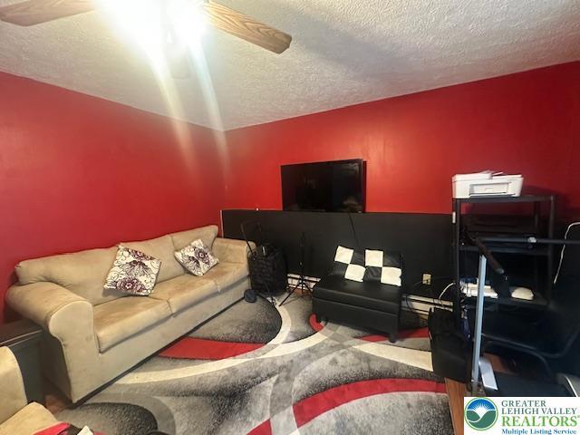 carpeted living area featuring a textured ceiling