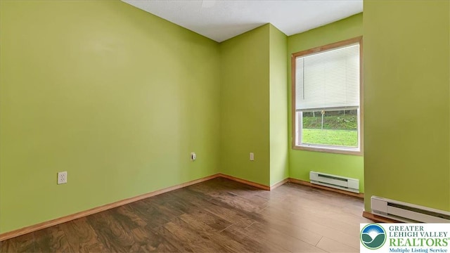 838 Cayuga Way, Stroud Twp, PA 18360 - unfurnished room featuring a baseboard heating unit and dark wood finished floors
