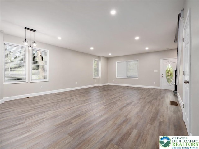 unfurnished living room featuring a wealth of natural light, visible vents, and recessed lighting