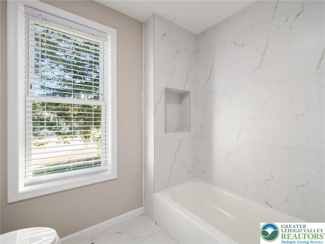 bathroom with marble finish floor, plenty of natural light, baseboards, and toilet