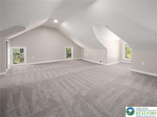 bonus room with vaulted ceiling and carpet floors