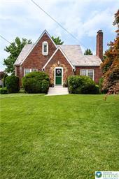 tudor house with a chimney and a front yard