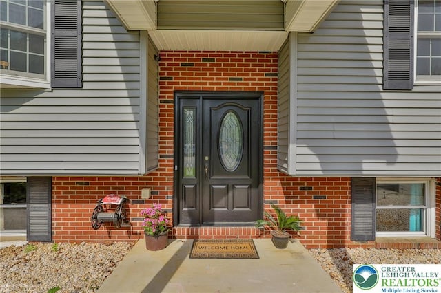 view of exterior entry with brick siding