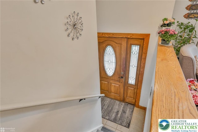 tiled entrance foyer featuring baseboards