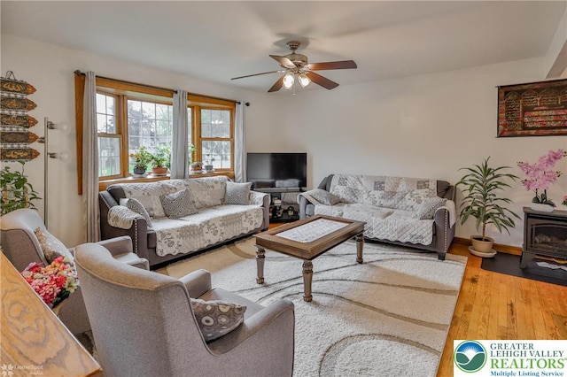 living area featuring a ceiling fan and wood finished floors