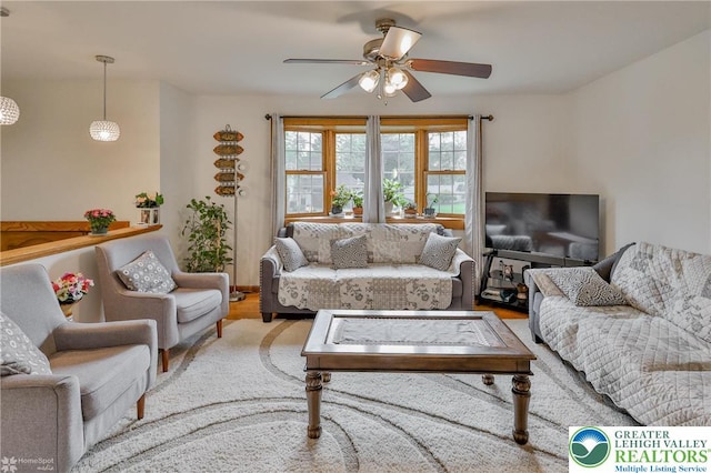 living area with a ceiling fan and wood finished floors
