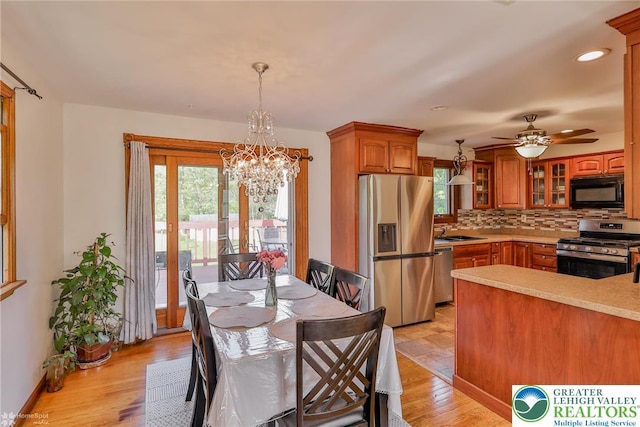 dining area with light wood-style flooring, recessed lighting, plenty of natural light, and ceiling fan with notable chandelier