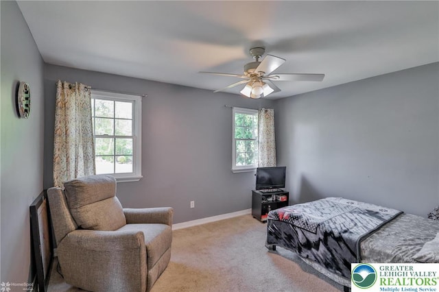 bedroom featuring baseboards, multiple windows, ceiling fan, and light colored carpet