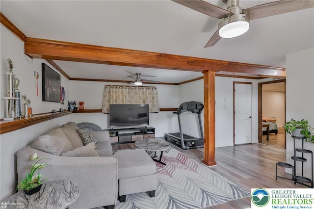living area with beam ceiling, ceiling fan, and wood finished floors