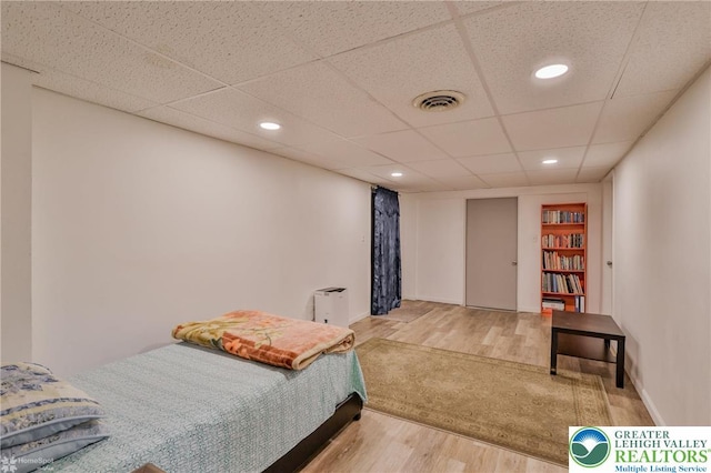 bedroom with baseboards, recessed lighting, visible vents, and wood finished floors