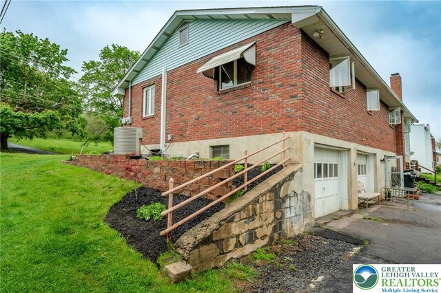 1804 Long Run Rd, Pa, PA 17972 - view of home's exterior featuring aphalt driveway, brick siding, a yard, a garage, and cooling unit