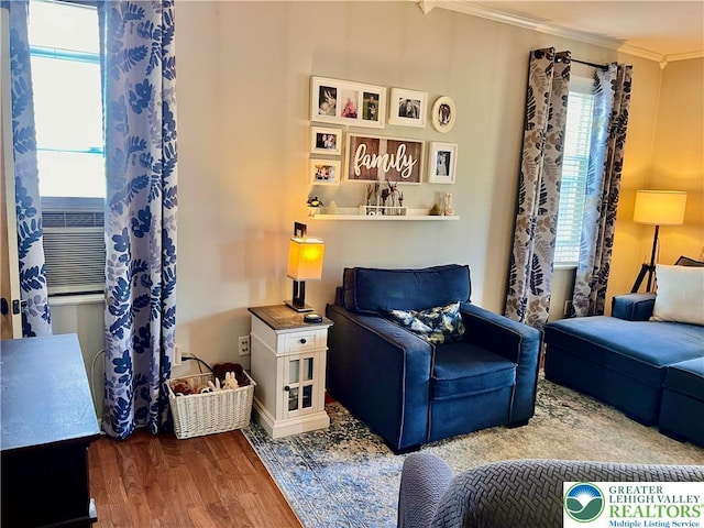 living area featuring ornamental molding and wood finished floors