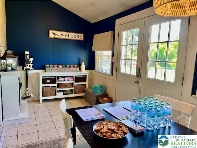 dining space with tile patterned floors and lofted ceiling