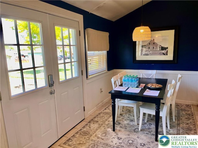 dining area with wainscoting and light tile patterned floors