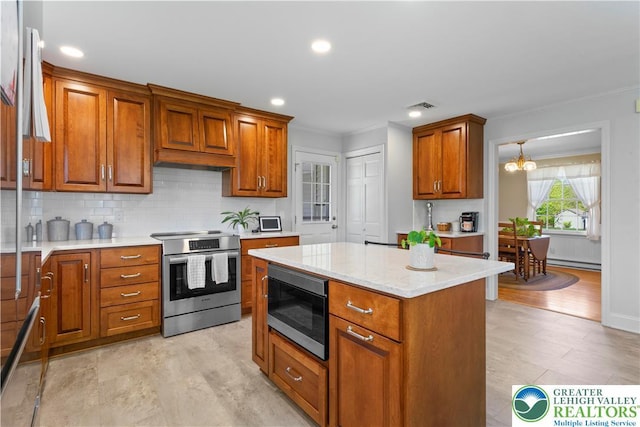 kitchen with crown molding, appliances with stainless steel finishes, brown cabinetry, and tasteful backsplash