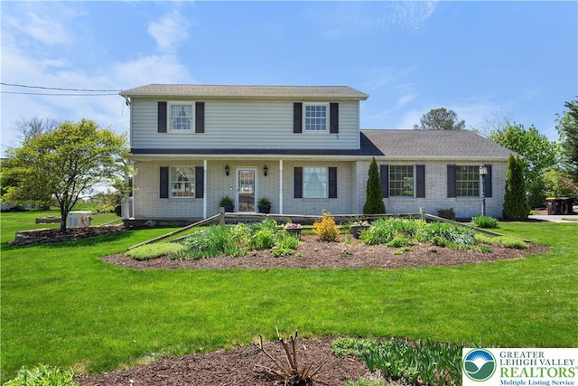 traditional-style house featuring central AC, covered porch, brick siding, and a front lawn
