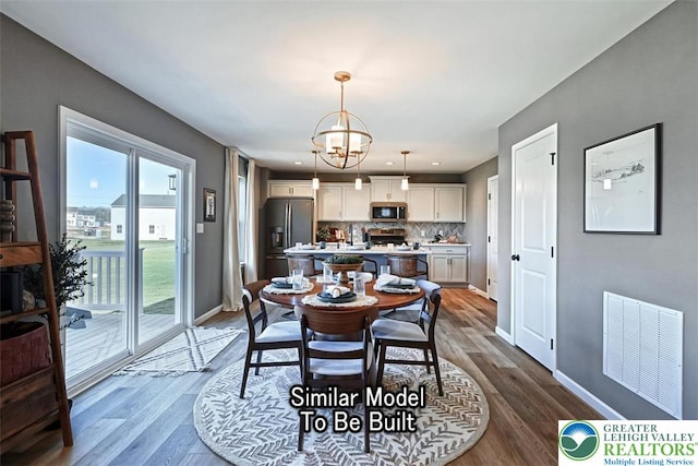 dining area with baseboards, dark wood finished floors, a chandelier, and visible vents