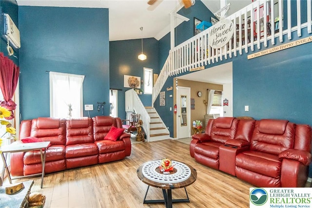 1231 Kensington Dr, Stroud Twp, PA 18301 - living area featuring stairway, a high ceiling, a ceiling fan, and wood finished floors
