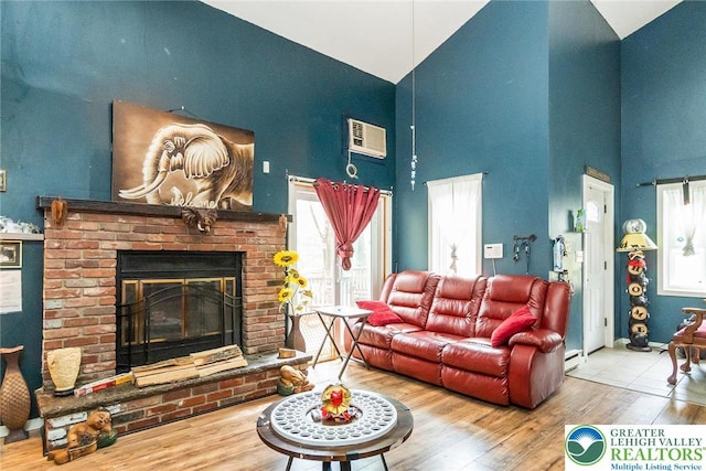 1231 Kensington Dr, Stroud Twp, PA 18301 - living area featuring baseboards, a fireplace, high vaulted ceiling, and wood finished floors