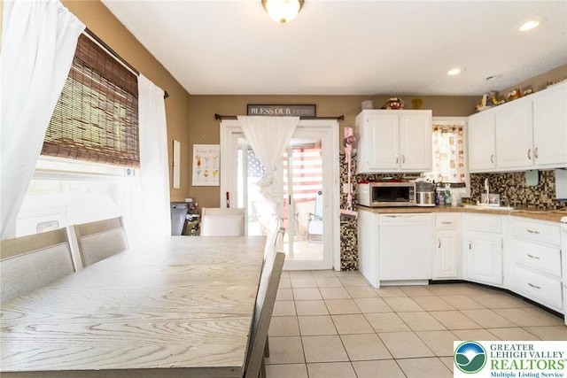 1231 Kensington Dr, Stroud Twp, PA 18301 - kitchen featuring stainless steel microwave, white cabinetry, decorative backsplash, and white dishwasher
