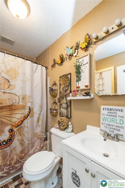 1231 Kensington Dr, Stroud Twp, PA 18301 - bathroom with a textured ceiling, toilet, visible vents, a shower with shower curtain, and vanity