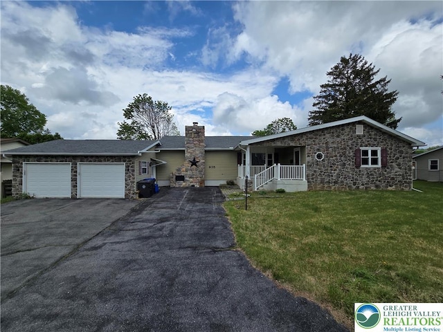 single story home with an attached garage, a chimney, a front lawn, and stone siding