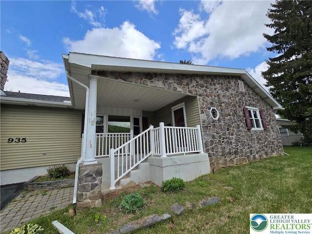view of front of property featuring stone siding and a front yard