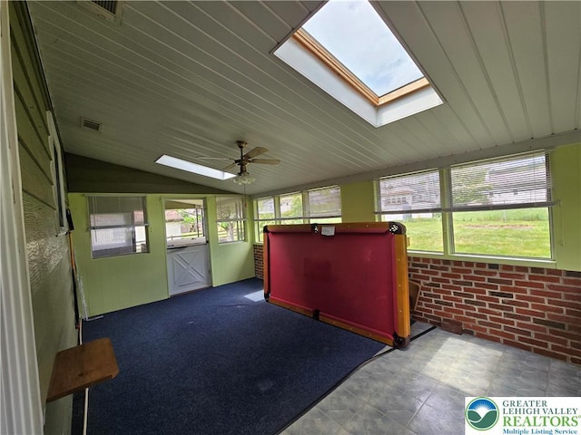 unfurnished sunroom with ceiling fan, a skylight, and a healthy amount of sunlight