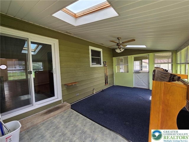 unfurnished sunroom with a ceiling fan and a skylight