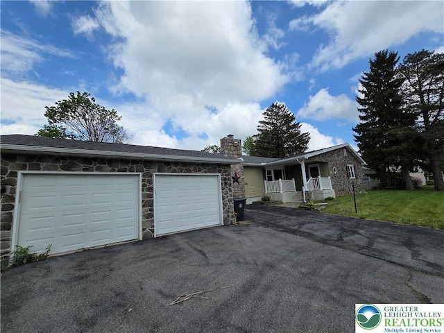 single story home with stone siding, driveway, a garage, a front lawn, and a chimney