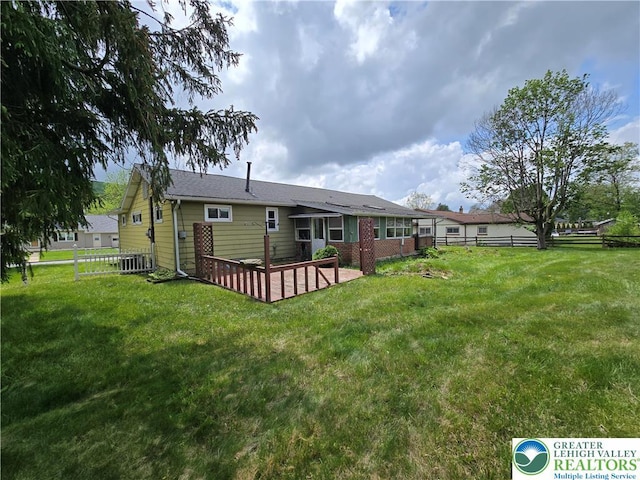 rear view of house featuring a yard, central AC, and fence