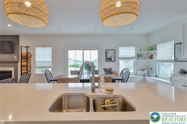 kitchen with plenty of natural light, open floor plan, a chandelier, and a sink