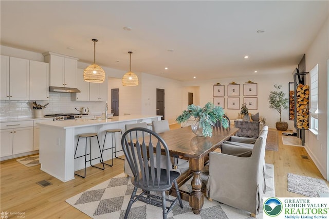 dining area featuring light wood-type flooring and recessed lighting