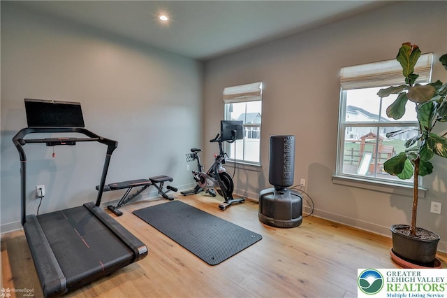 workout room featuring baseboards, recessed lighting, and wood finished floors