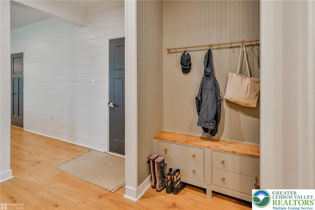 mudroom featuring baseboards, beamed ceiling, and wood finished floors